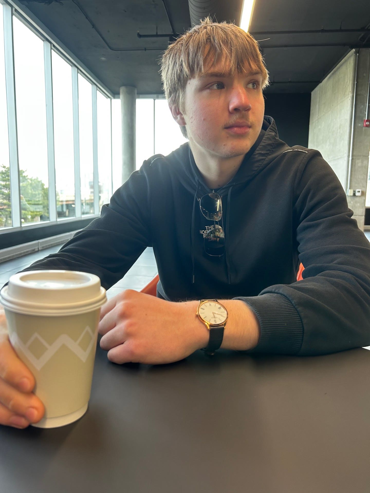 David sitting with coffee in a modern study space