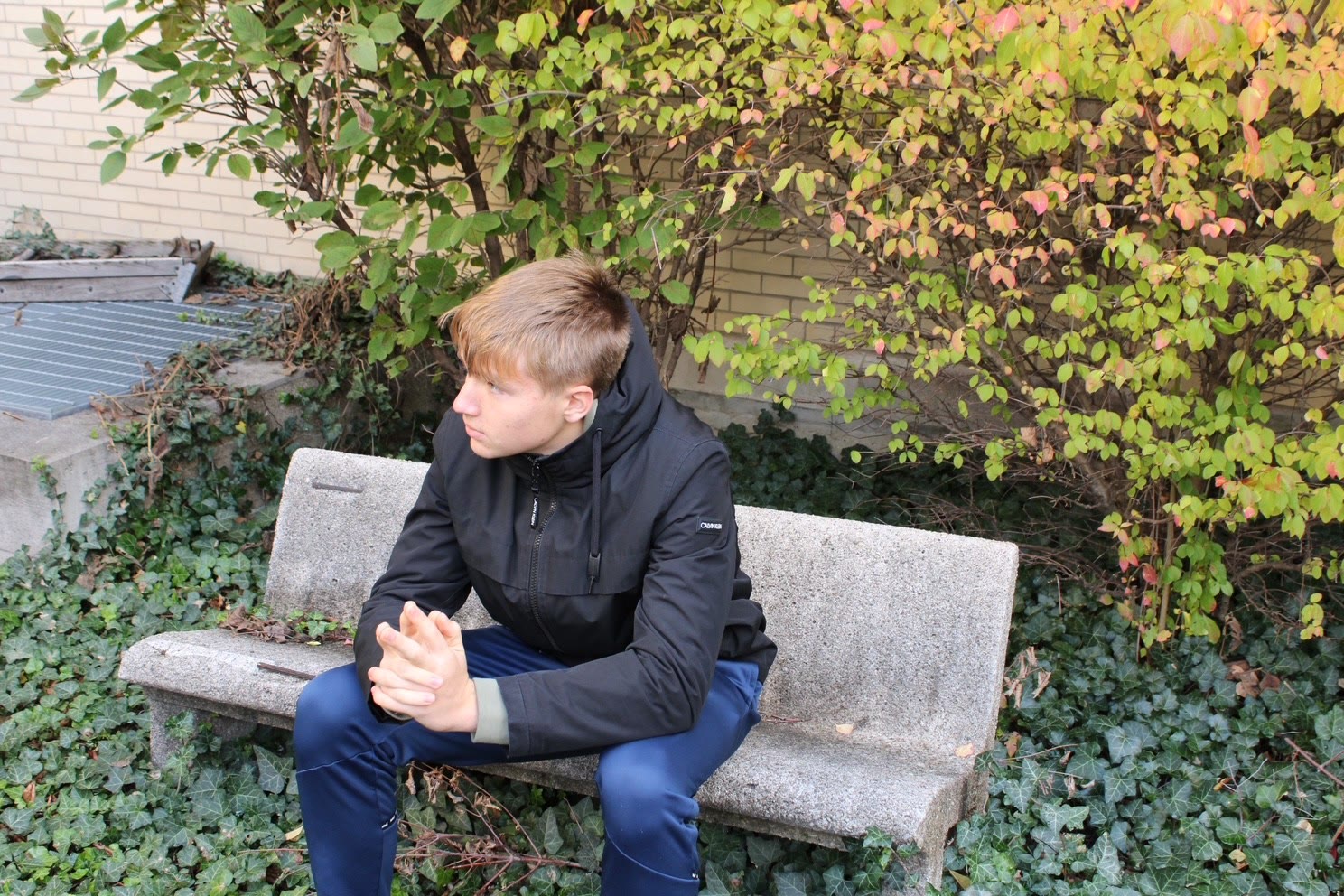 David sitting outdoors on a stone bench