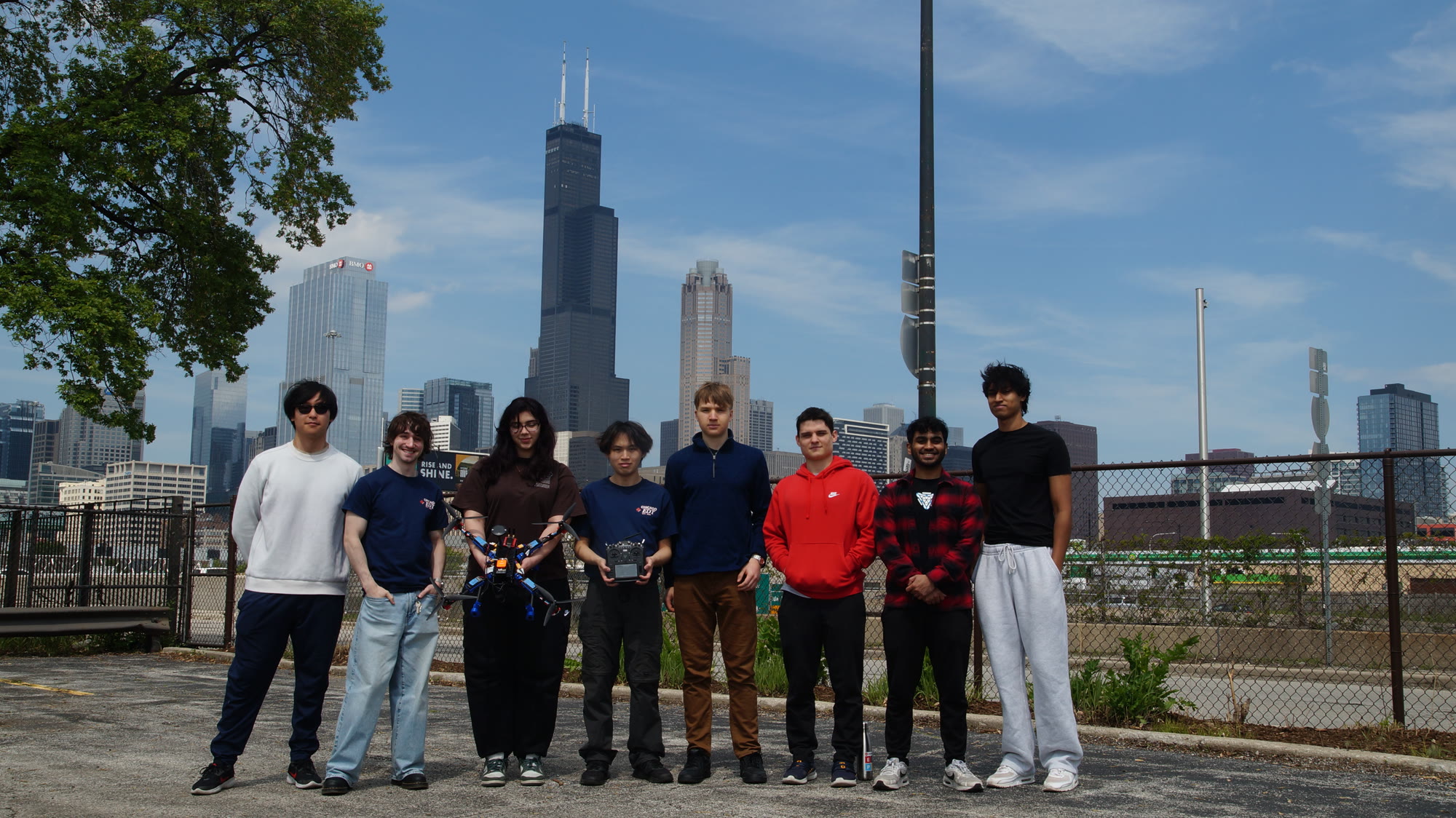 Student drone team standing with the aircraft and Chicago skyline behind them