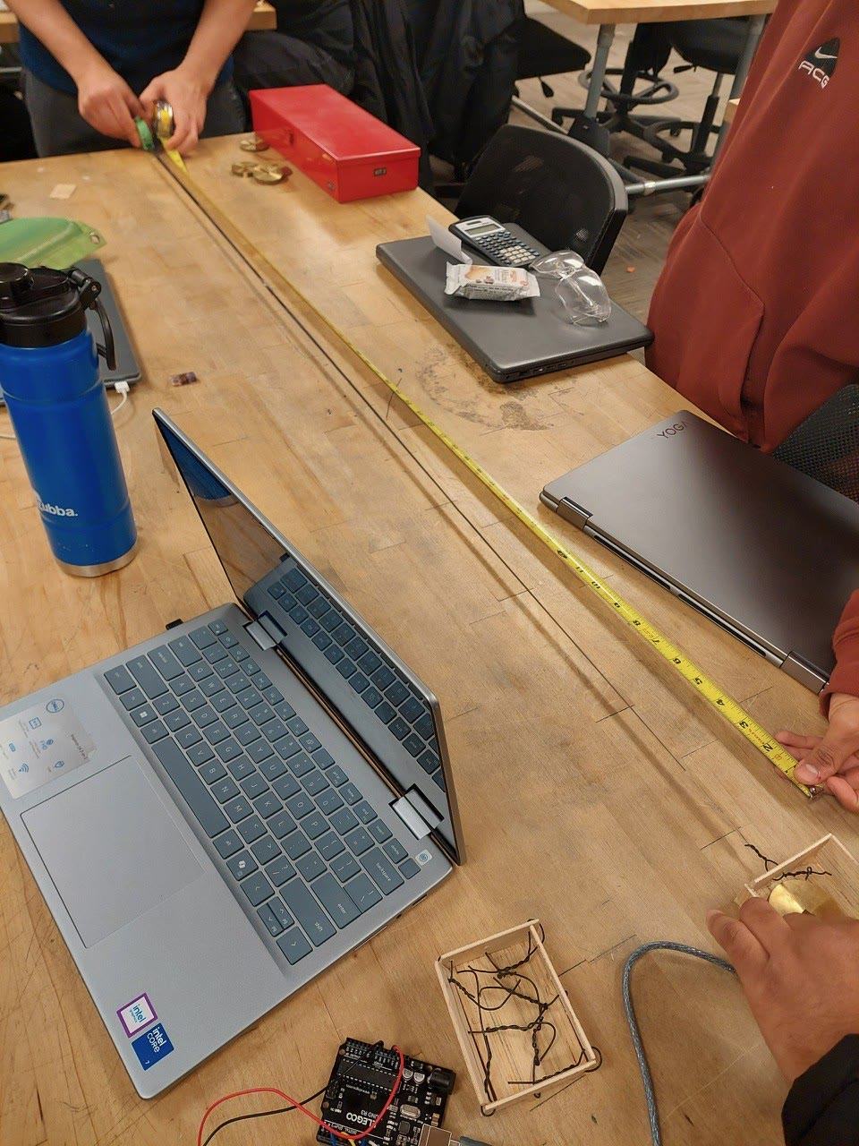 Team measuring the physical track beside the prototype electronics